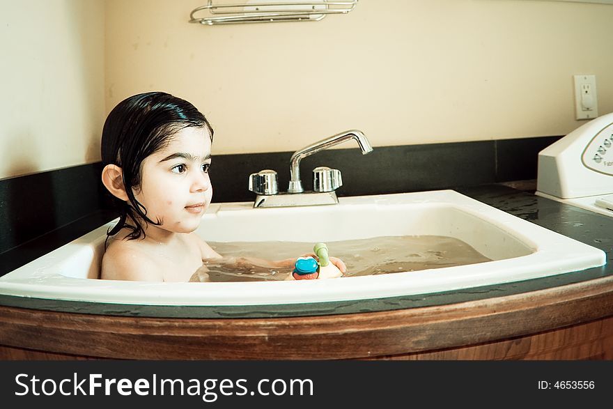 This child is having bath in a normal washbasin. This child is having bath in a normal washbasin.