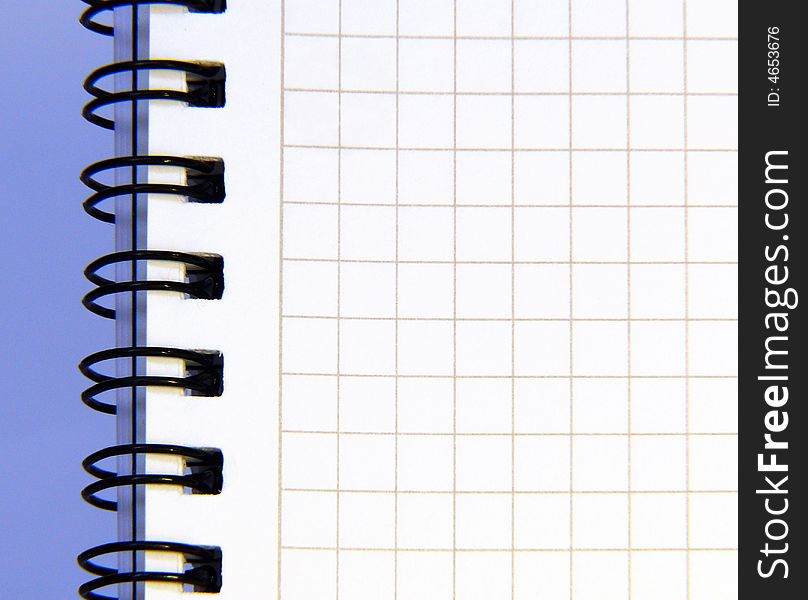 Notebook sheet on blue background. Close up. Notebook sheet on blue background. Close up.