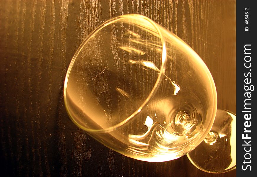 Glass to wine on wooden background in brown color.