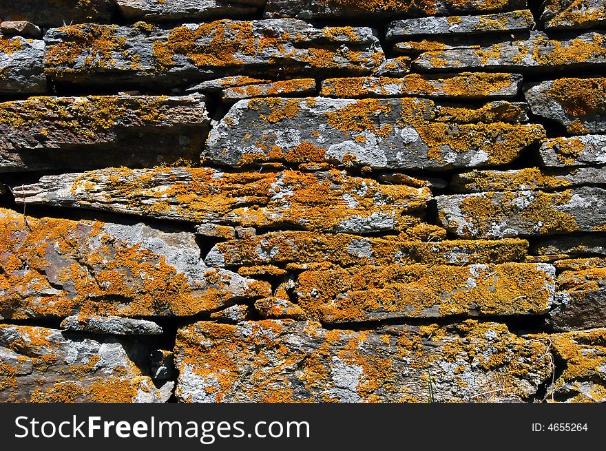 Old ancient mossy wall, moss all over, stone was used as bricks. Old ancient mossy wall, moss all over, stone was used as bricks