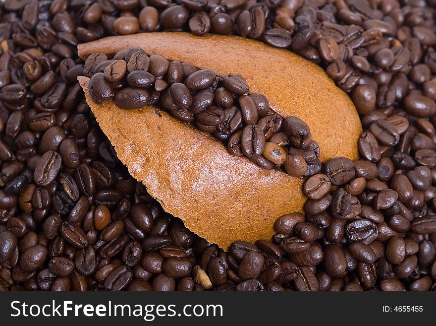 Piece of rye-bread in stack of coffee beans. Piece of rye-bread in stack of coffee beans