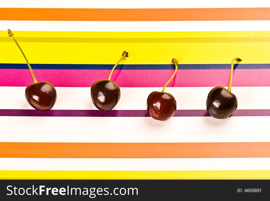 Some ripe cherries on the colored background. Some ripe cherries on the colored background