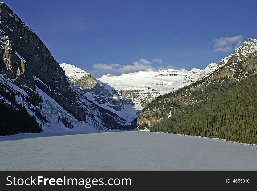 Lake louise frozen over with bright blue sky in background