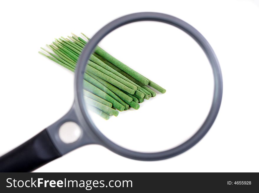 Incense sticks seen through magnifier.Isolated on white background.