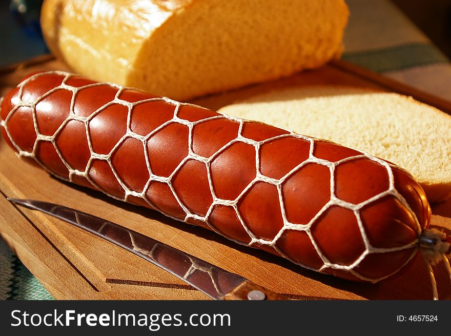 Sausage and bread on a kitchen board. Sausage and bread on a kitchen board