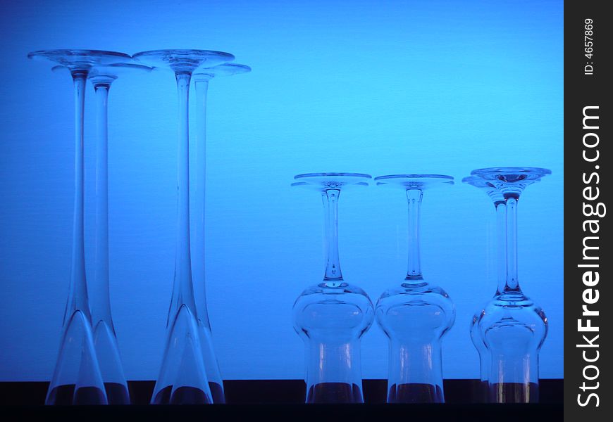 Grappa and liquor glasses in front of a blue lighted background of a hotel bar