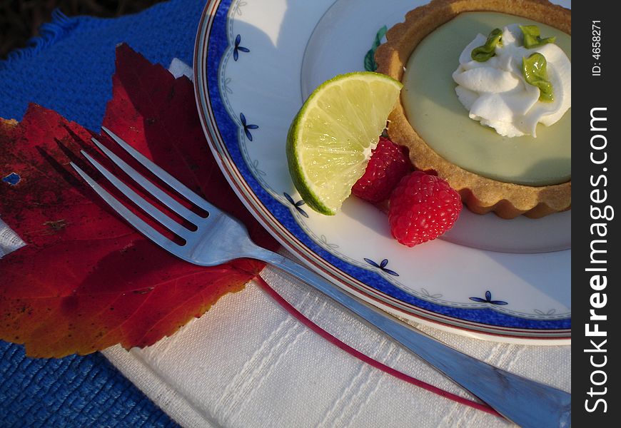 Key Lime tart with lime wedge and raspberries. Key Lime tart with lime wedge and raspberries