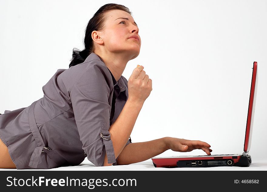 Attractive brunette woman lying on white background with laptop. Attractive brunette woman lying on white background with laptop