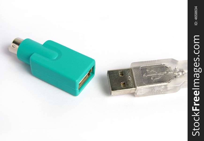 Green usb to ps2 connector and a usb cable in a white background. Isolated photo.