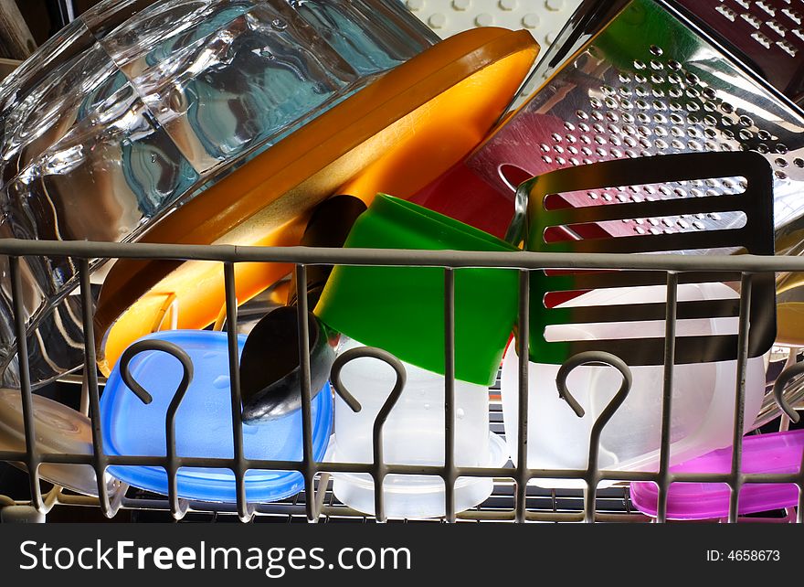 Colorful kitchen items sit in a drying rack.