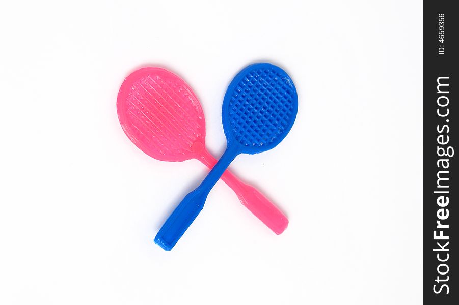 Two tennis racket toys, blue and pink. Isolated photo.