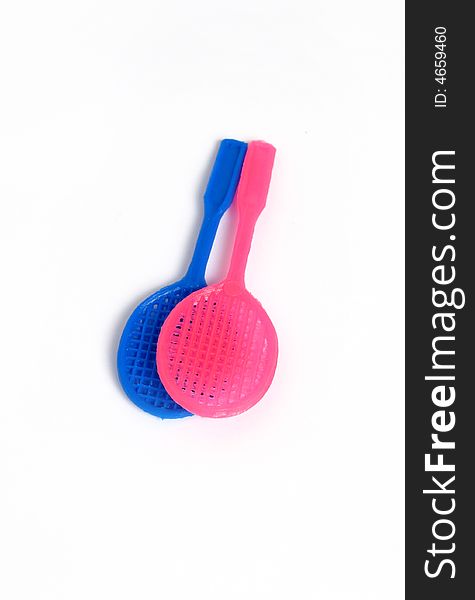 Two tennis racket toys, blue and pink. Isolated photo.