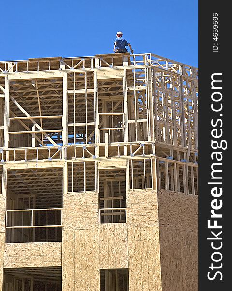 A framer on a wood structure under construction. A framer on a wood structure under construction