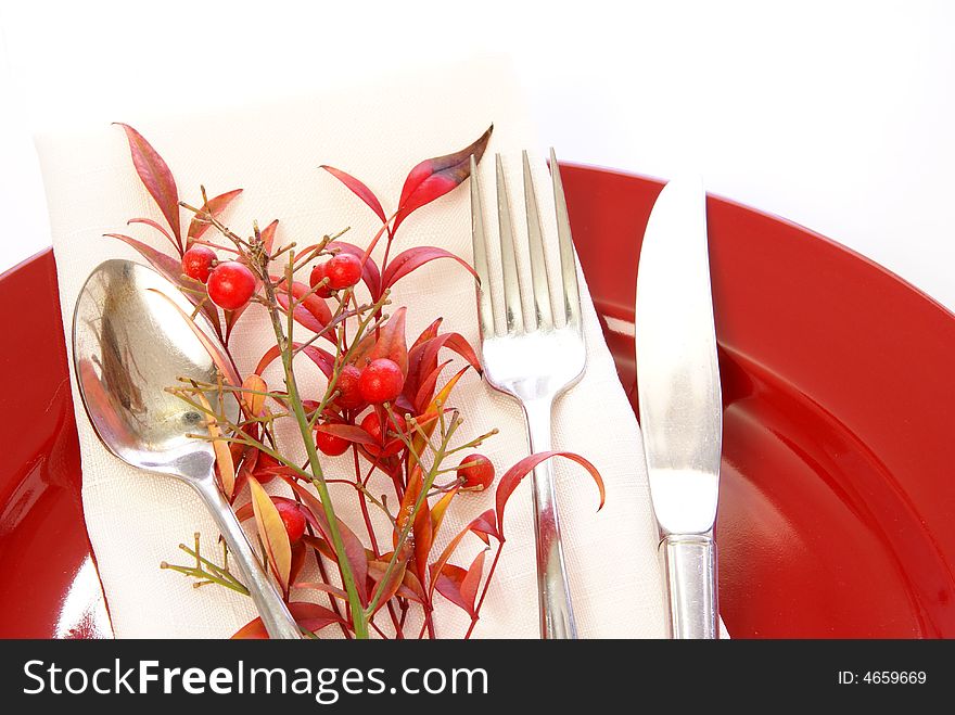 Elegant table setting in red and white, with fresh sprigs of leaves and berries. Elegant table setting in red and white, with fresh sprigs of leaves and berries