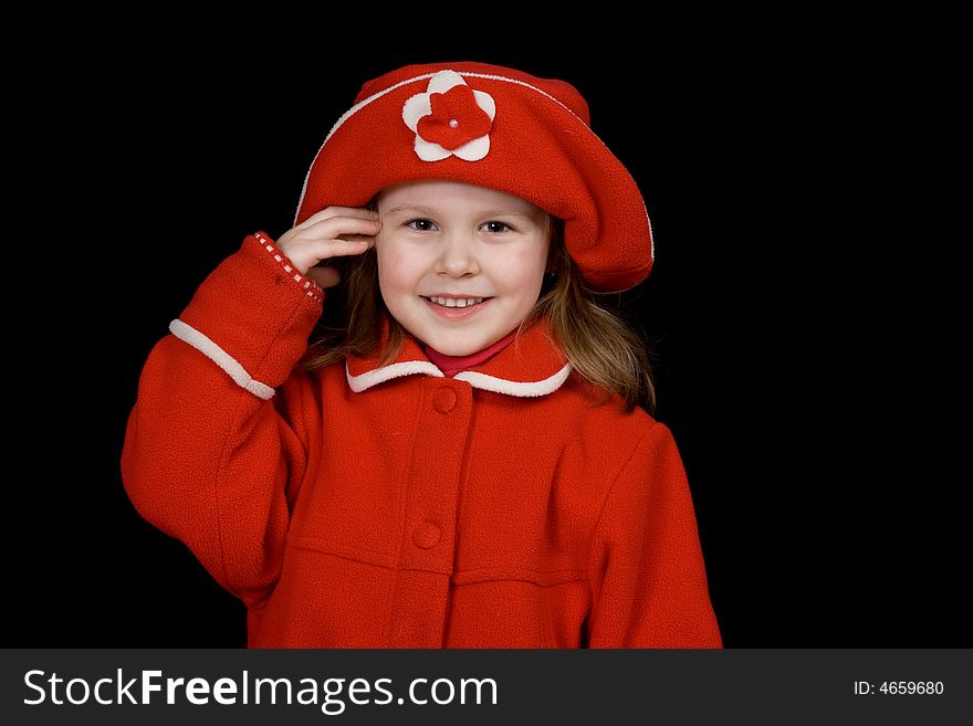 The child in a red coat and a red cap smiles, having taken a hand in a head