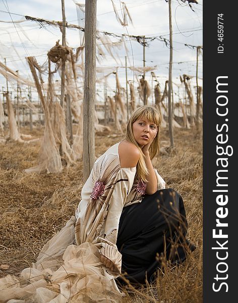 Fashion Girl Sitting In A Field