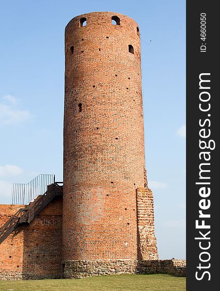 Ruin of old castle, tower on background of the blue sky