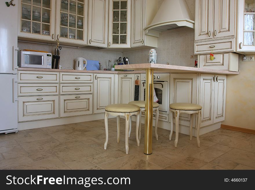 Interior of kitchen with a table and tablewares in light tones