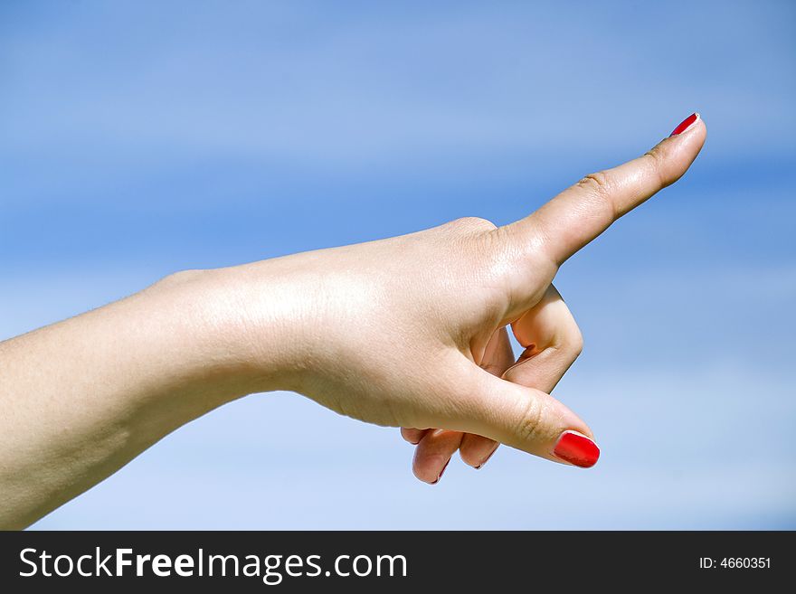 Woman hand show direction on blue sky background. Woman hand show direction on blue sky background