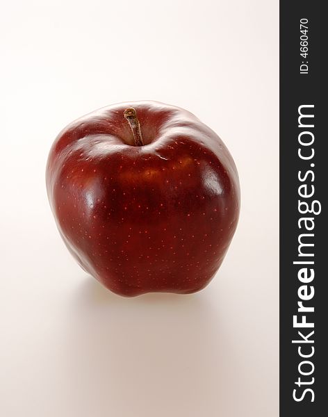 A juicy deep red shiny apple isolated on white. A juicy deep red shiny apple isolated on white.