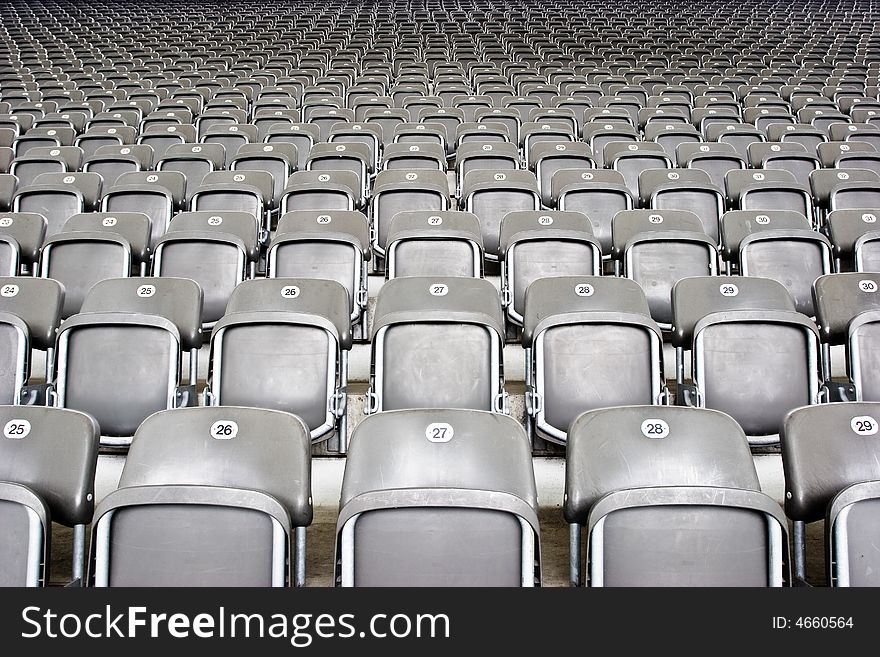 Rows and rows of empty grey seating at an event. Rows and rows of empty grey seating at an event