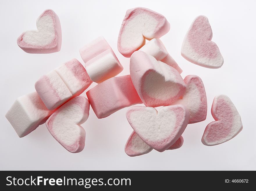Floating heart shaped marshmallows on a white background.