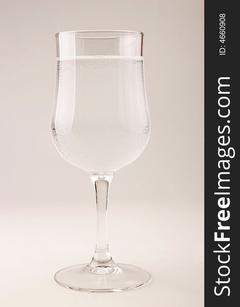 A glass goblet filled with sparkling water. A glass goblet filled with sparkling water