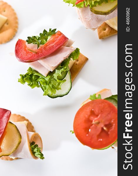 Food theme: cracker with ham, cheese and vegetables on the plate. Food theme: cracker with ham, cheese and vegetables on the plate
