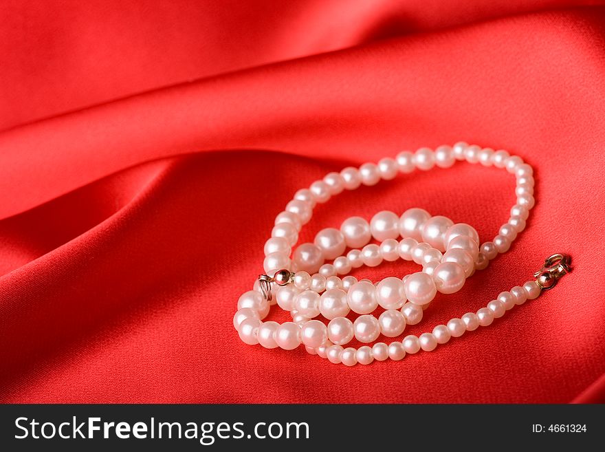 Beautiful pearl necklace over red background