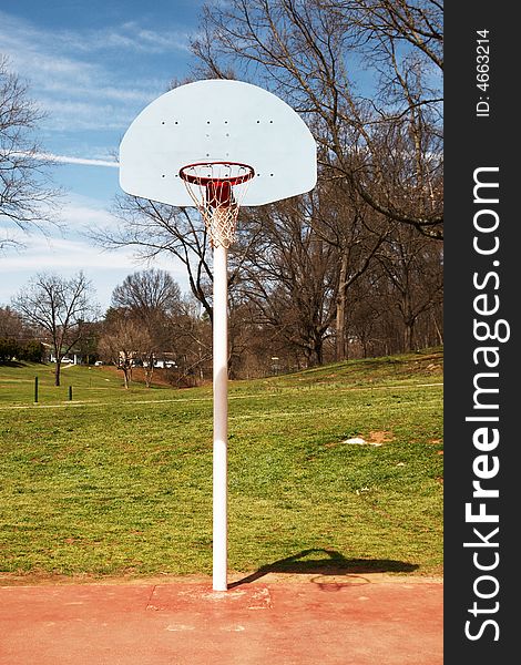 Basketball hoop on a red court at a park. Basketball hoop on a red court at a park