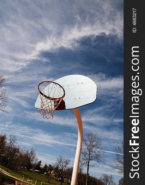 Basketball hoop on a red court at a park. Basketball hoop on a red court at a park