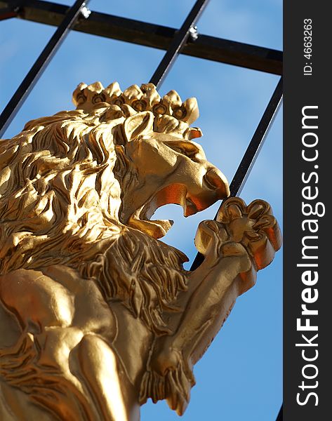 A golden lion on a cast iron gate