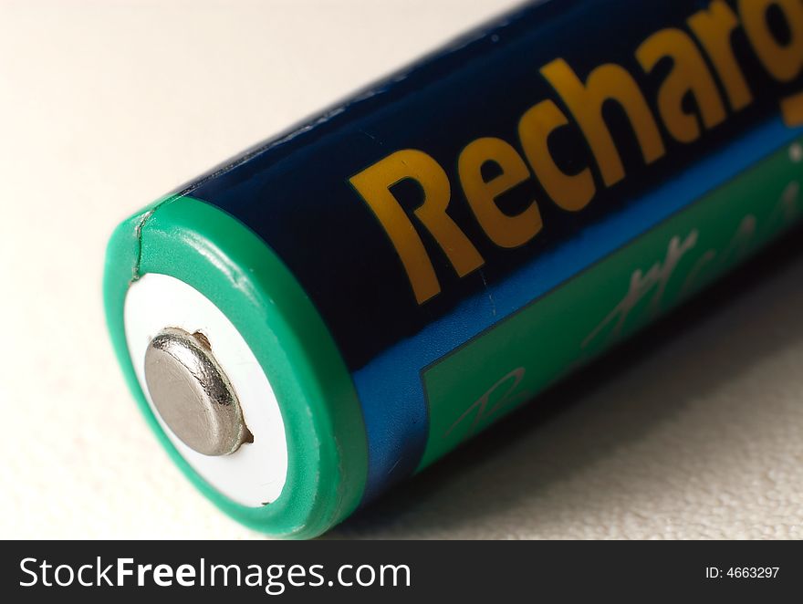 A aa rechargeable battery on white showing the positive charge side. A aa rechargeable battery on white showing the positive charge side.