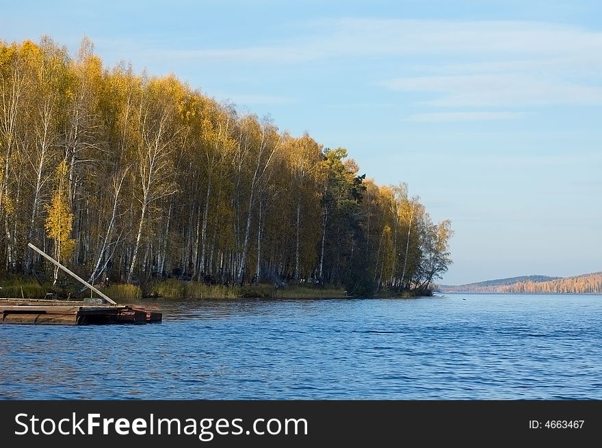 Autumn landscape with yellow forest at the coast of lake. Autumn landscape with yellow forest at the coast of lake