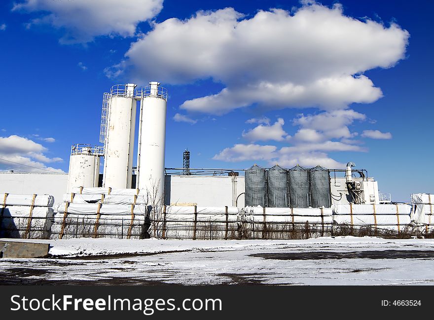 Chemical combinate with snow and blue clouded sky