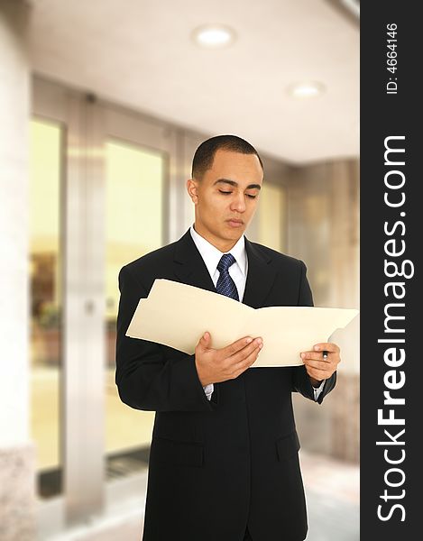 Business man still reading his folder when getting off from his office building main entrance. Business man still reading his folder when getting off from his office building main entrance