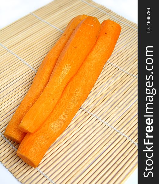 Peeled carrot on bamboo carpet background.