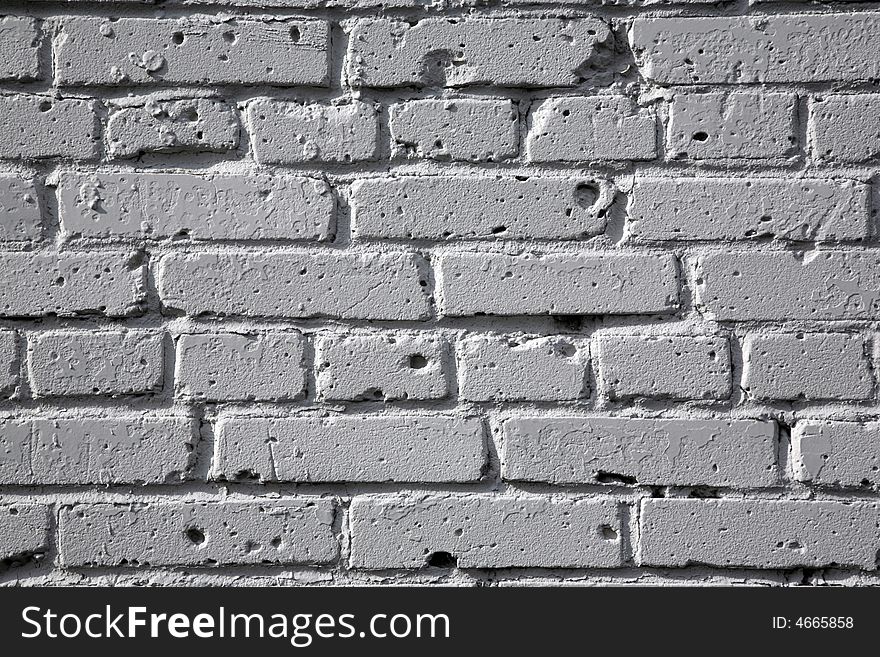 Brick wall painted by a white paint