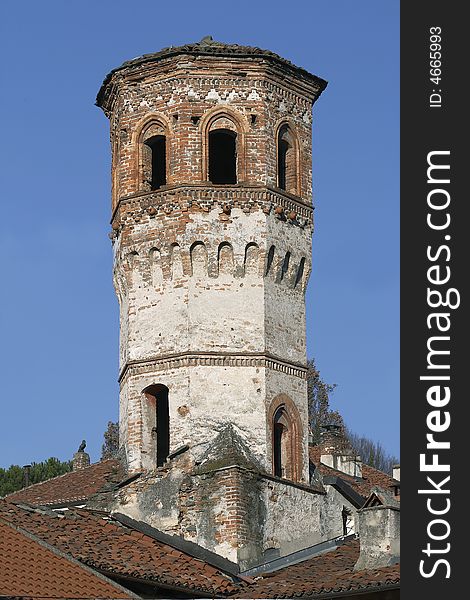 A mediaeval clock tower dating back to the 14th century in the town of Avigliana, Piedmont, Italy. The finely detailed brickwork is well preserved. A mediaeval clock tower dating back to the 14th century in the town of Avigliana, Piedmont, Italy. The finely detailed brickwork is well preserved.