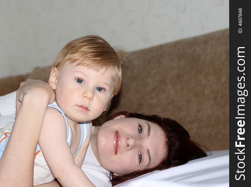 Young mum with the small beautiful son lay on a sofa. Young mum with the small beautiful son lay on a sofa