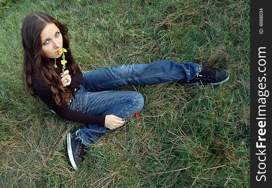 Beautiful teenage girl sitting on the grass