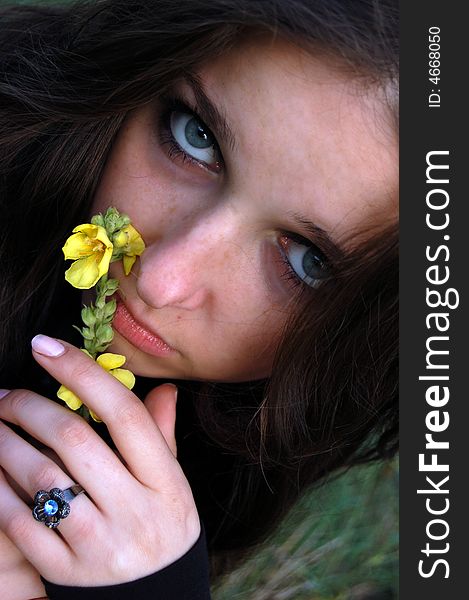 Beautiful teenage girl playing with a flower