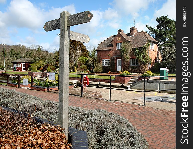 Lock and Lock Keepers House on the Thames River Path in England with Footpath sign in the foreground. Lock and Lock Keepers House on the Thames River Path in England with Footpath sign in the foreground