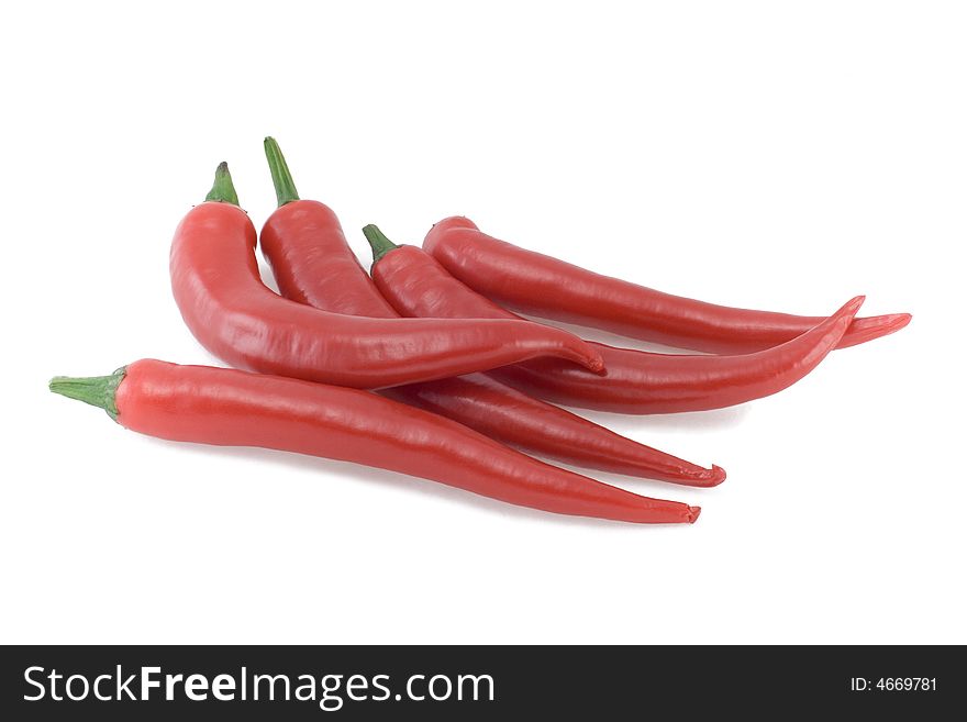 Five red hot chili peppers isolated on white