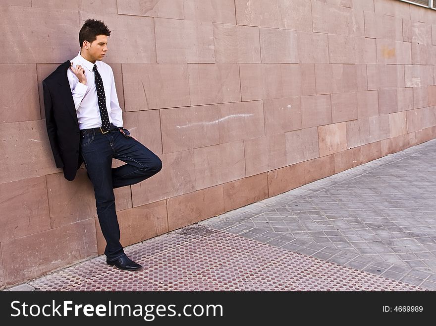 Lone businessman posing on wall. Lone businessman posing on wall