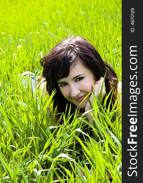 Smiling blonde woman portrait over the grass. Smiling blonde woman portrait over the grass