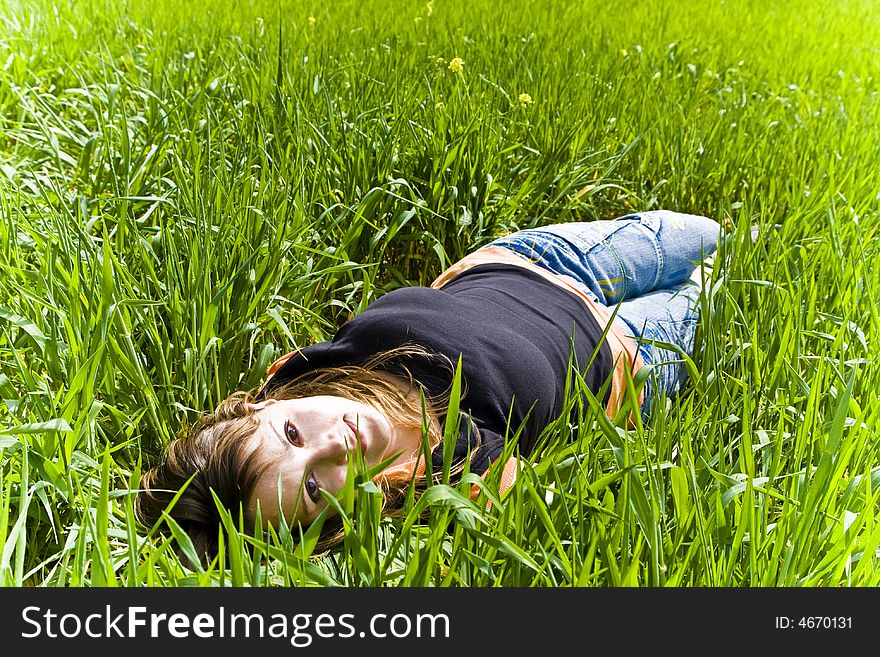 Smiling blonde woman portrait over the grass. Smiling blonde woman portrait over the grass