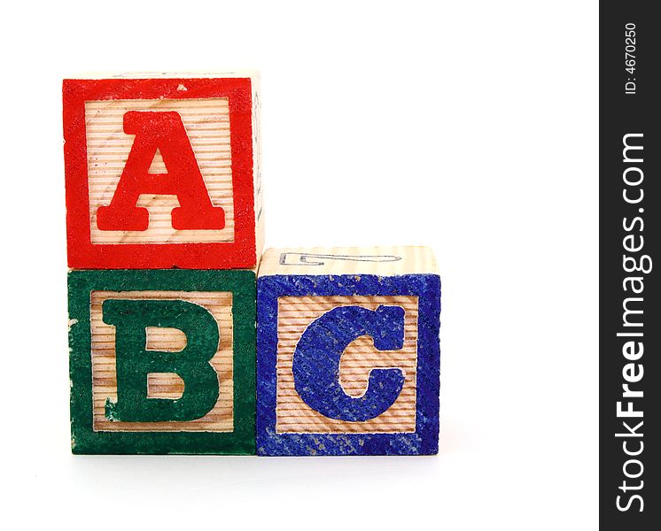 Letter wood blocks forming the sequence abc on a white surface