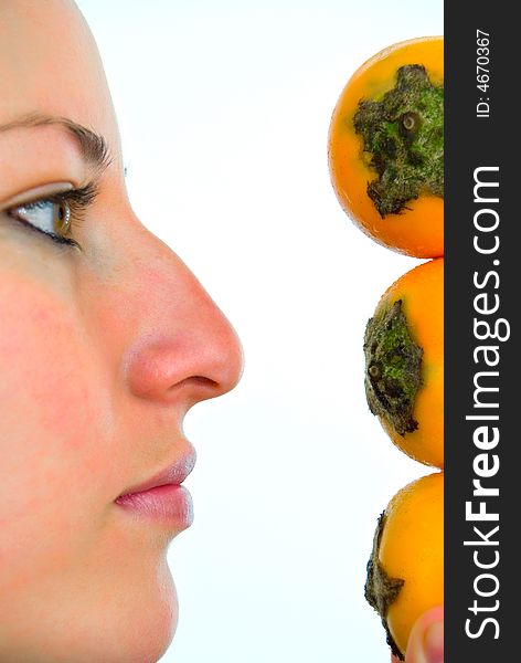 Young lady closely looking at three yellow fruits