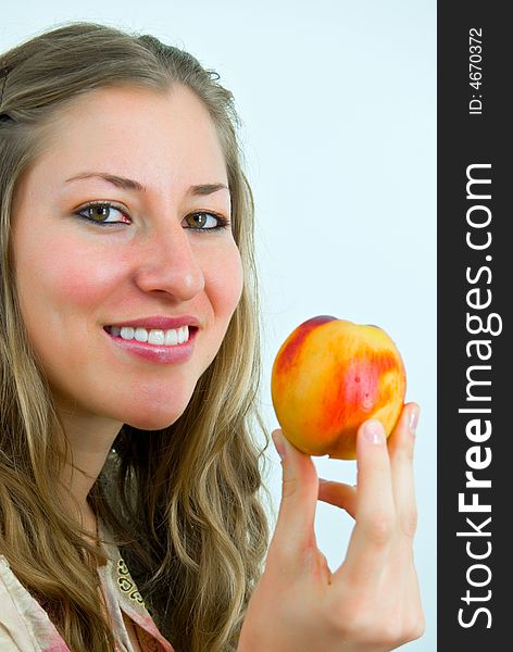 Smiling attractive young lady with a fresh colorful peach. Smiling attractive young lady with a fresh colorful peach